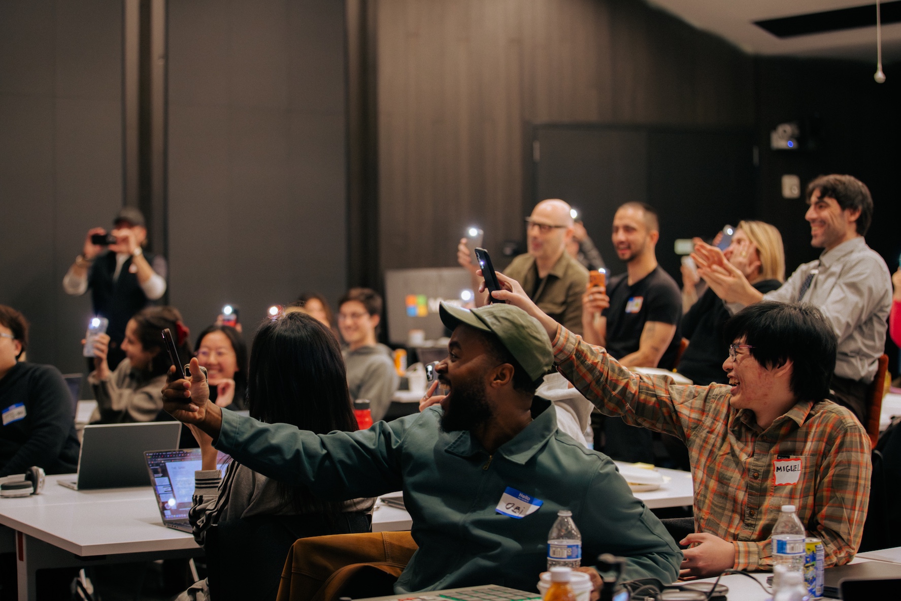 Audience laughing and using their phone flashlights